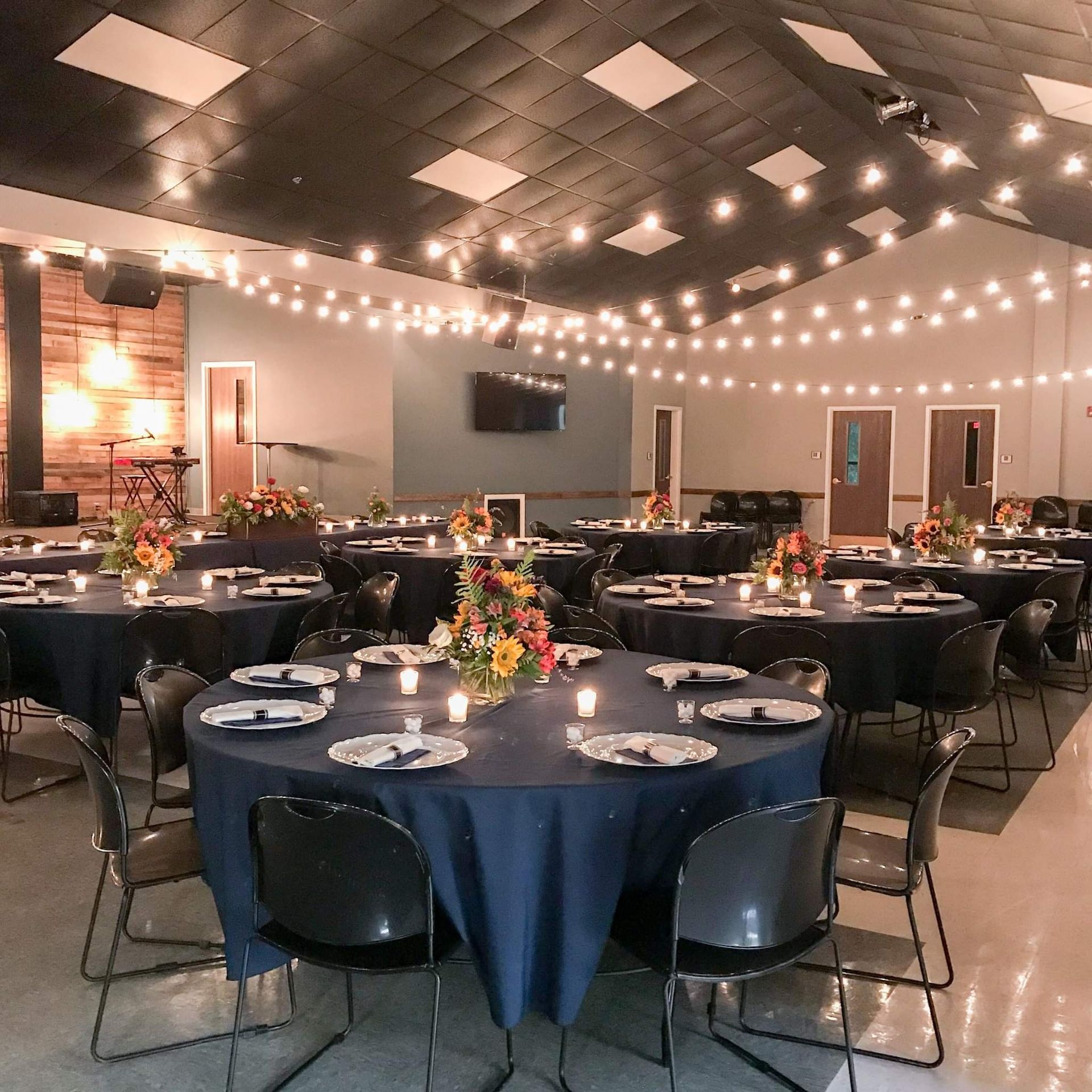 A large room with tables and chairs set up for a party.