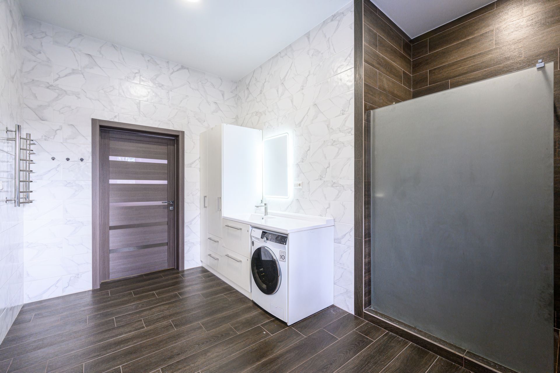 View of a modern bathroom with a fading shower screen on the left side. View of a modern bathroom with a fading shower screen on the left side.
