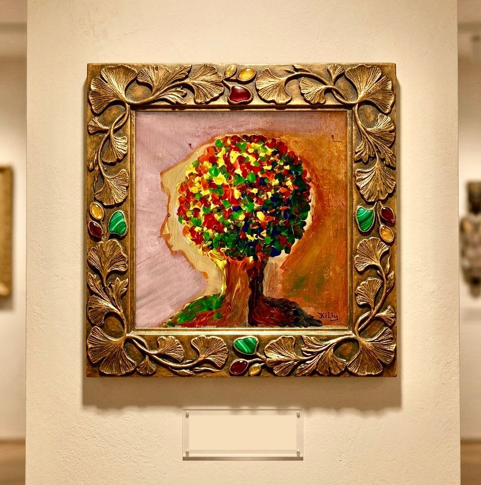 Ingelijst, gestructureerd schilderij van een kleurrijke boom met groene en rode bladeren aan een galeriemuur.