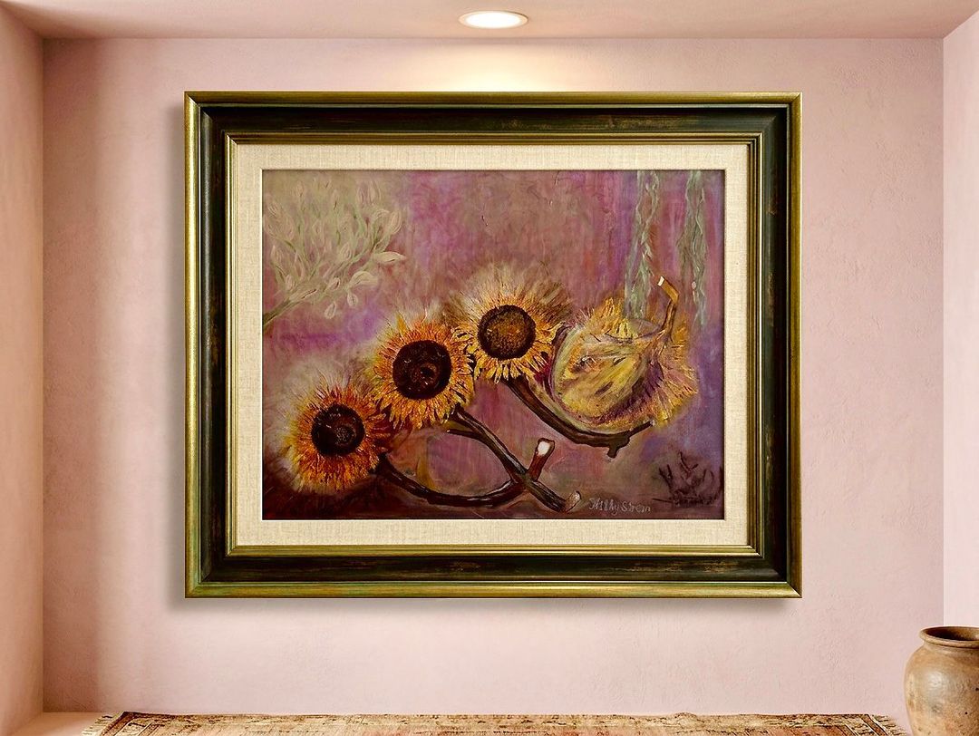 Ingelijst schilderij met paarse en gouden bloemen, hangend aan een lichte muur in een nis.