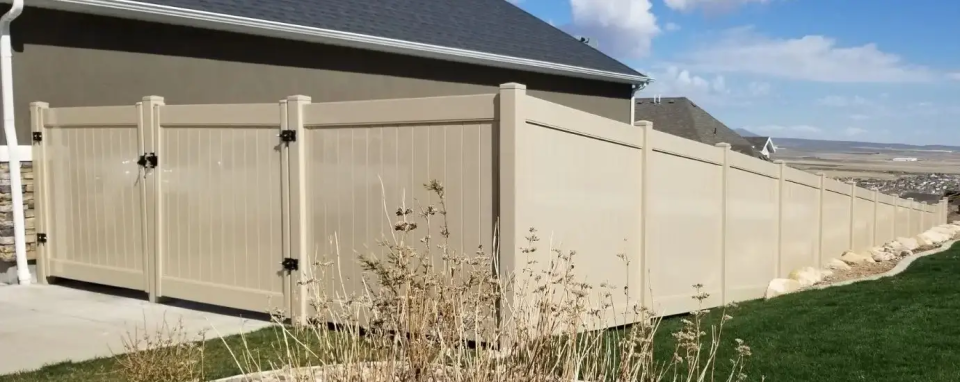 A white picket fence is in front of a house