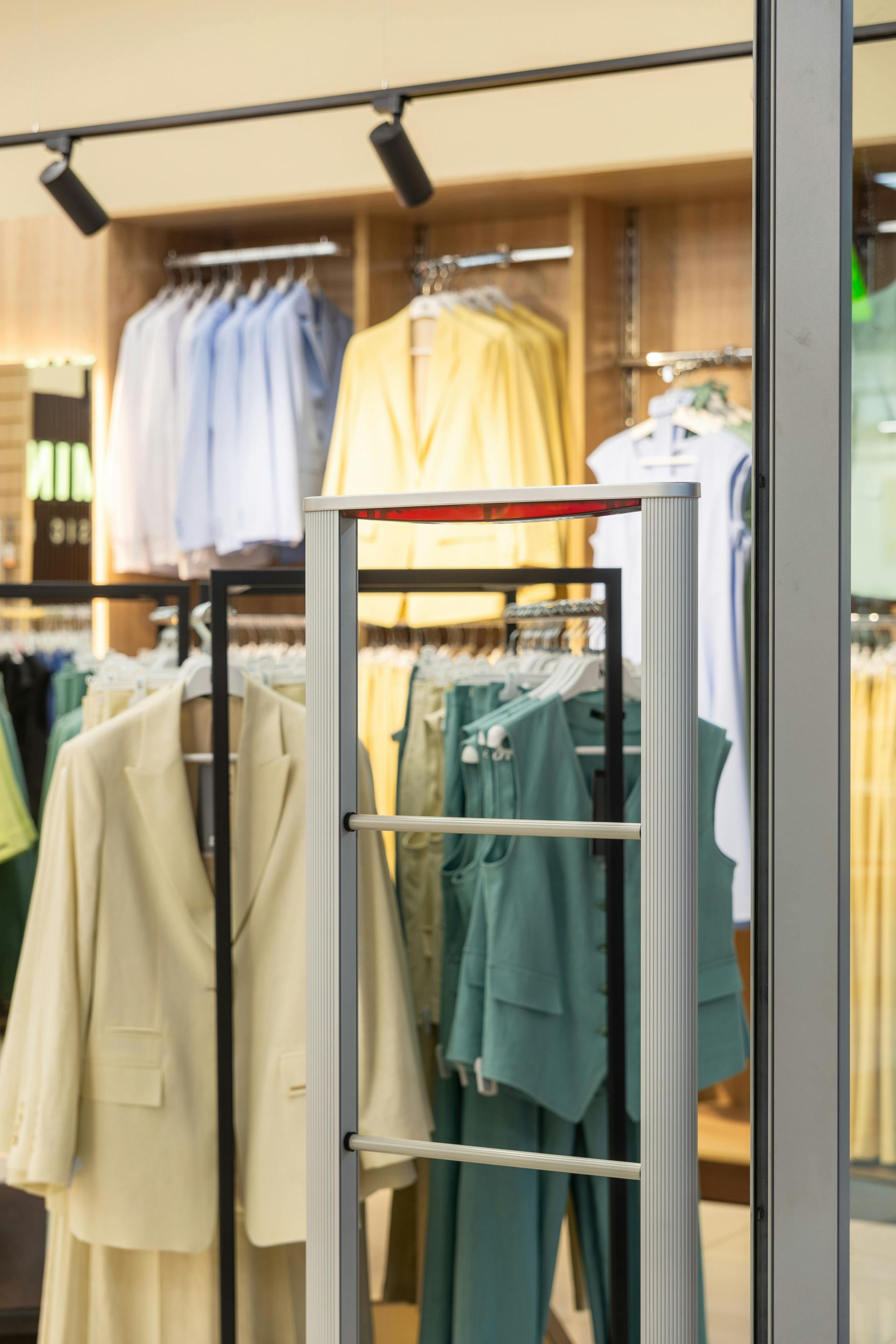 Clothing store display with shirts, jackets, and pants on racks and hangers