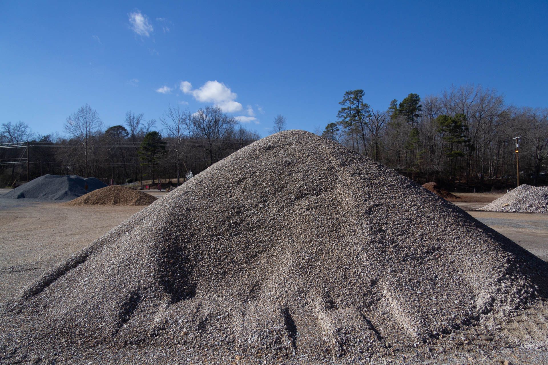 A pile of gravel is sitting on top of a dirt field.