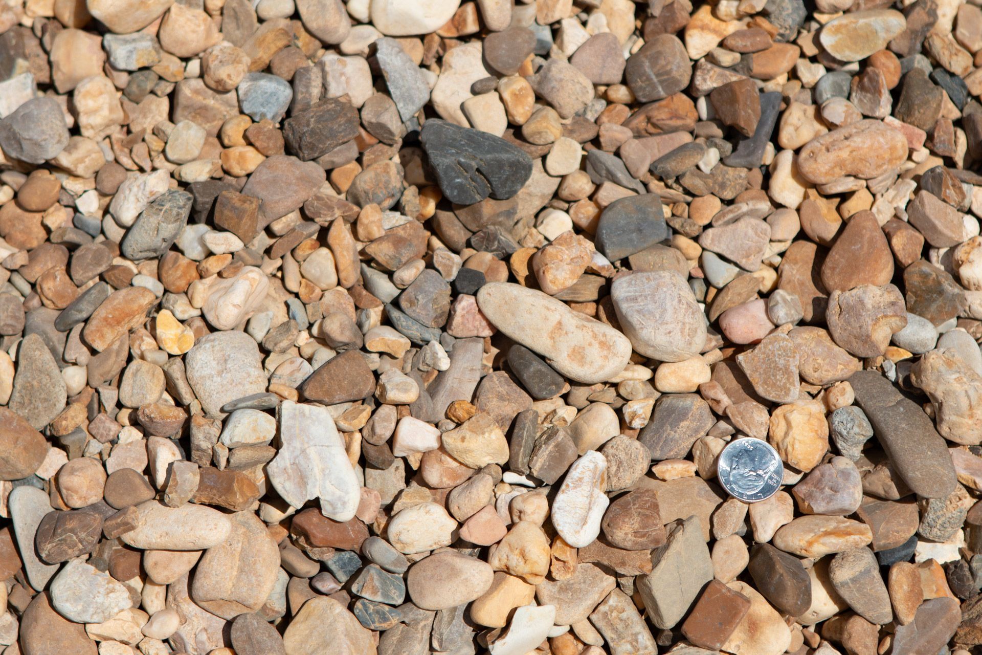 A pile of rocks with a quarter in the middle