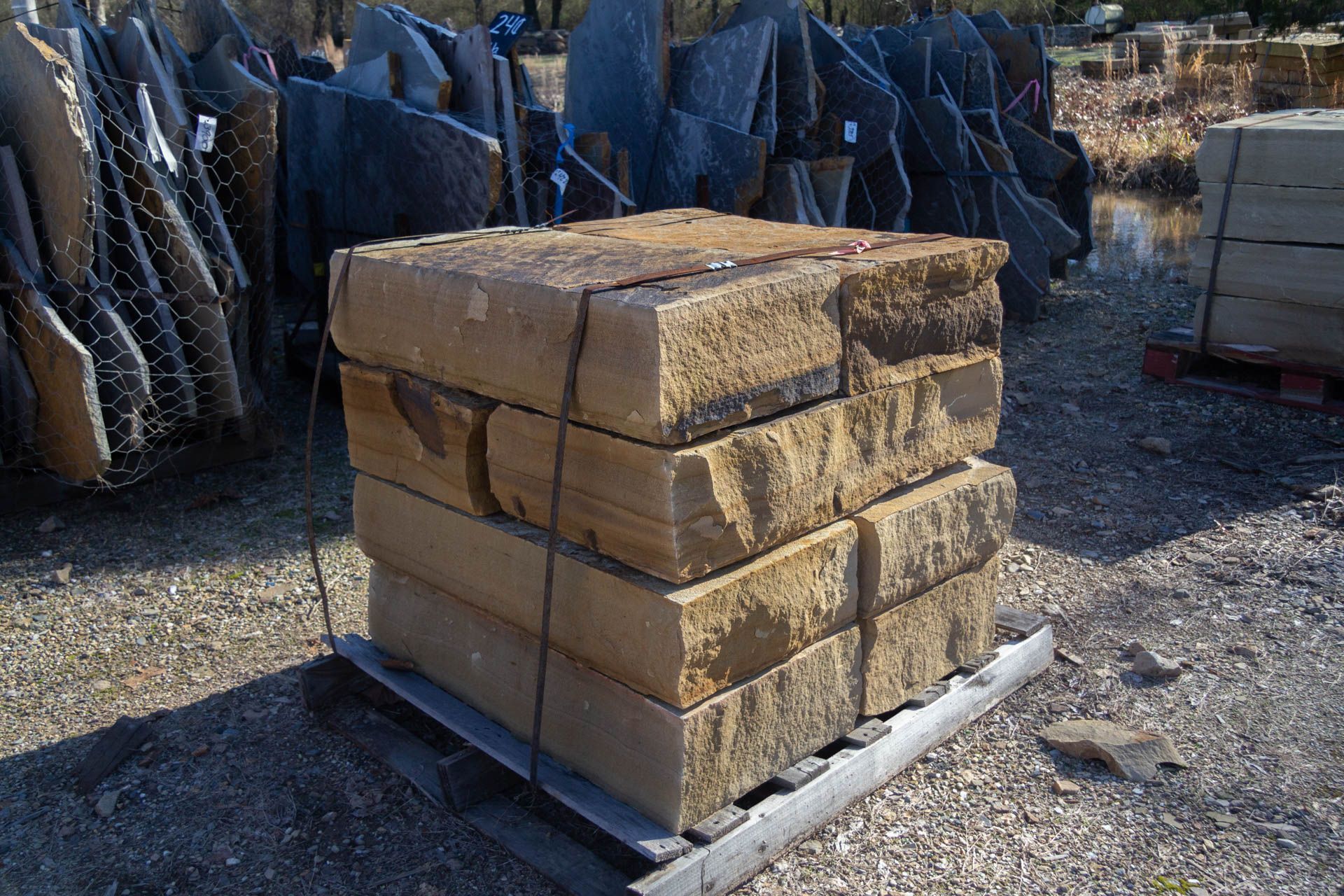 A pile of bricks stacked on top of each other on a wooden pallet.