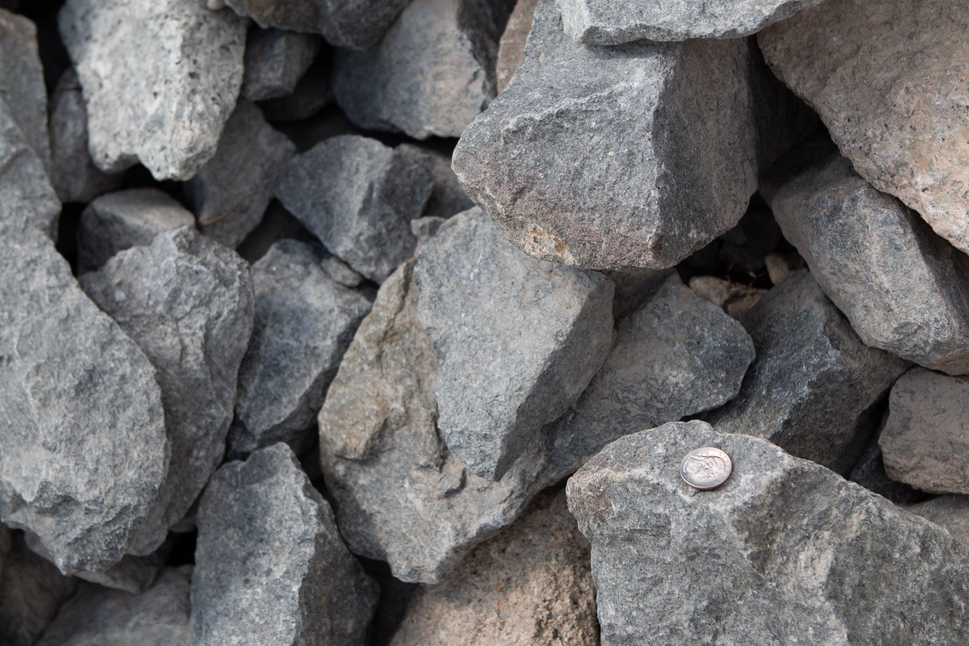 A pile of rocks with a penny sticking out of one of them.