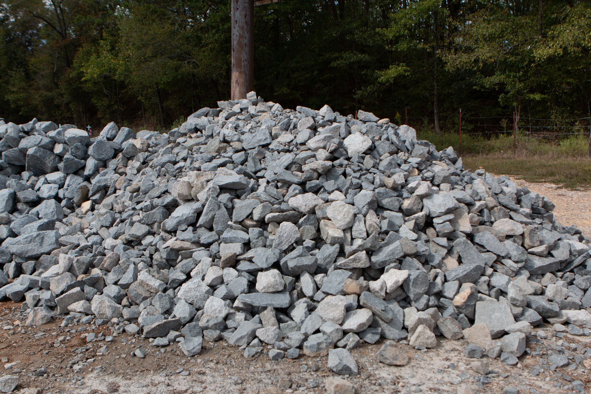 A pile of rocks is sitting on top of a dirt field.