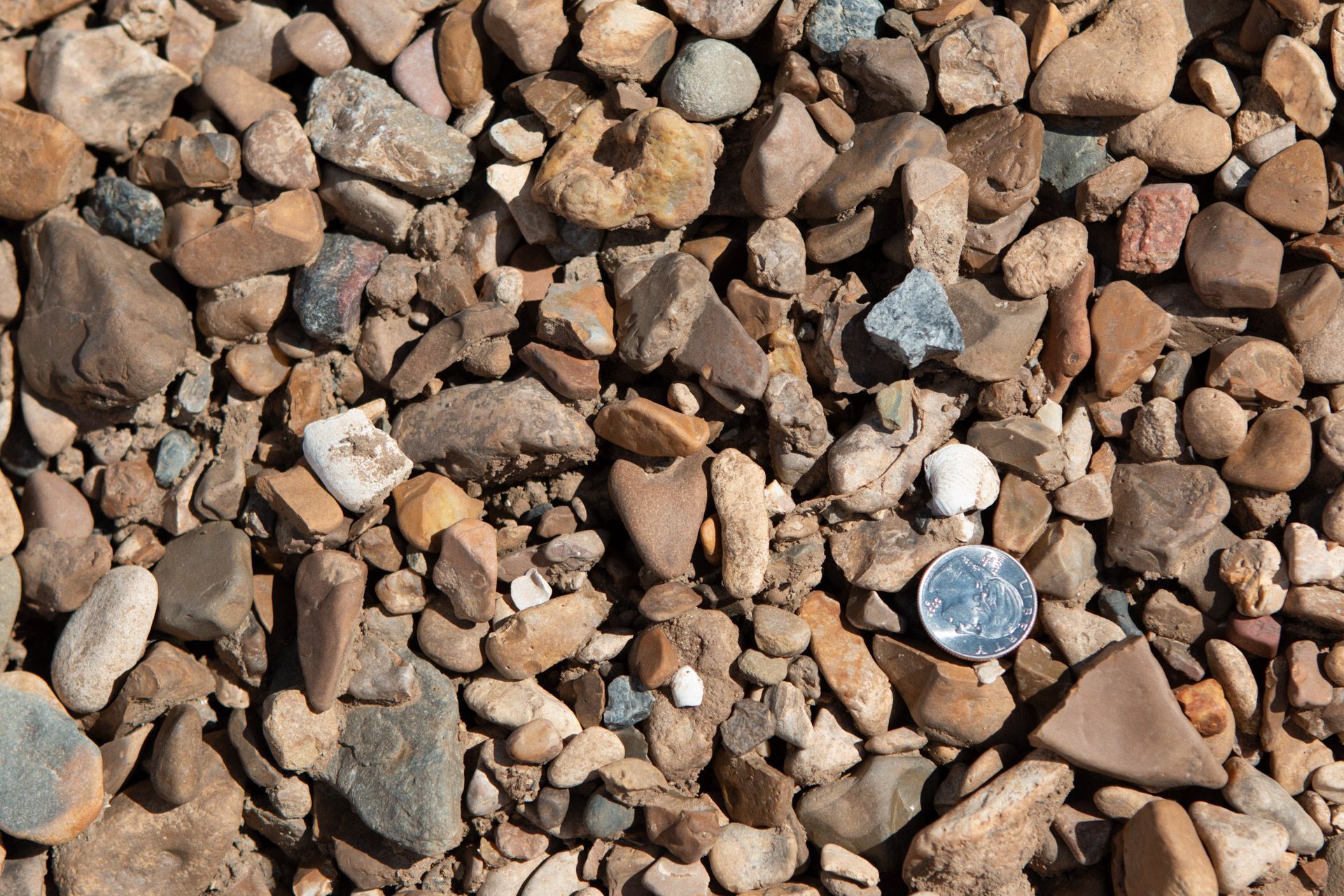 A pile of rocks with a quarter in the middle