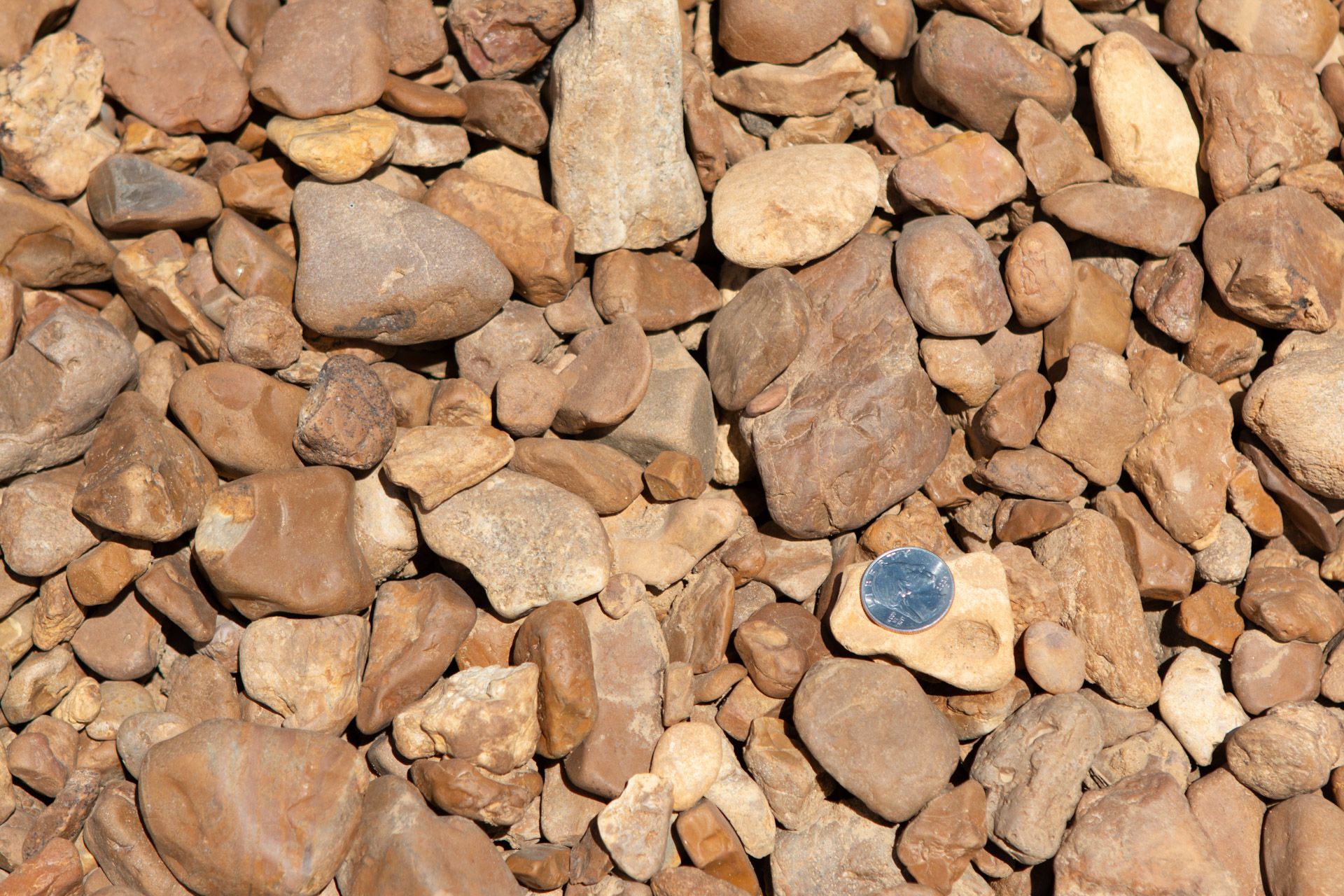 A pile of rocks with a coin in the middle.