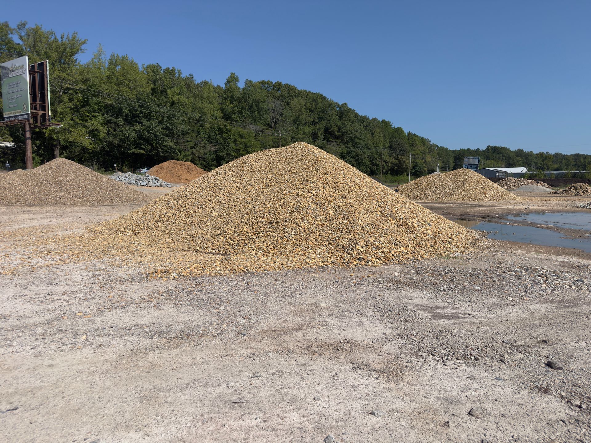 A large pile of rocks is sitting on top of a dirt field.