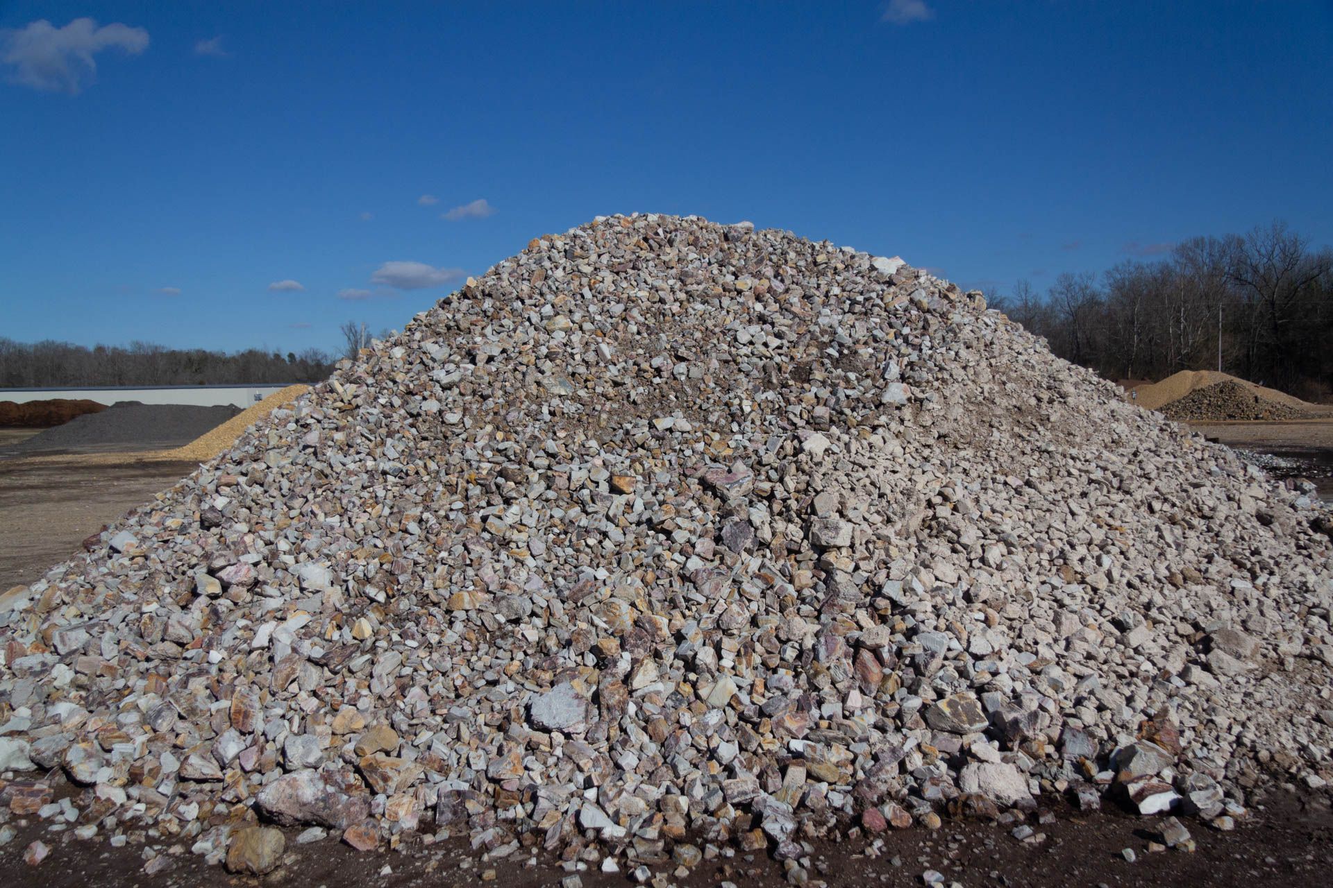 A large pile of rocks is sitting on top of a dirt field.