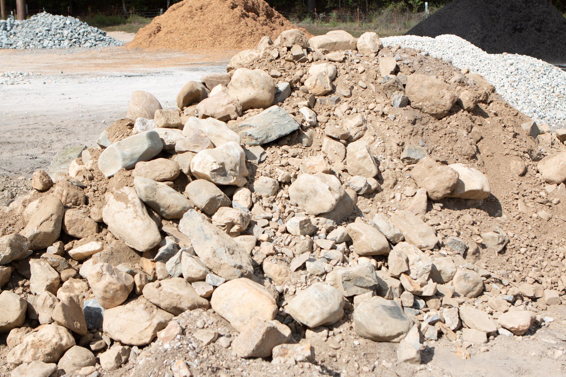 A pile of rocks is sitting on top of a pile of dirt.
