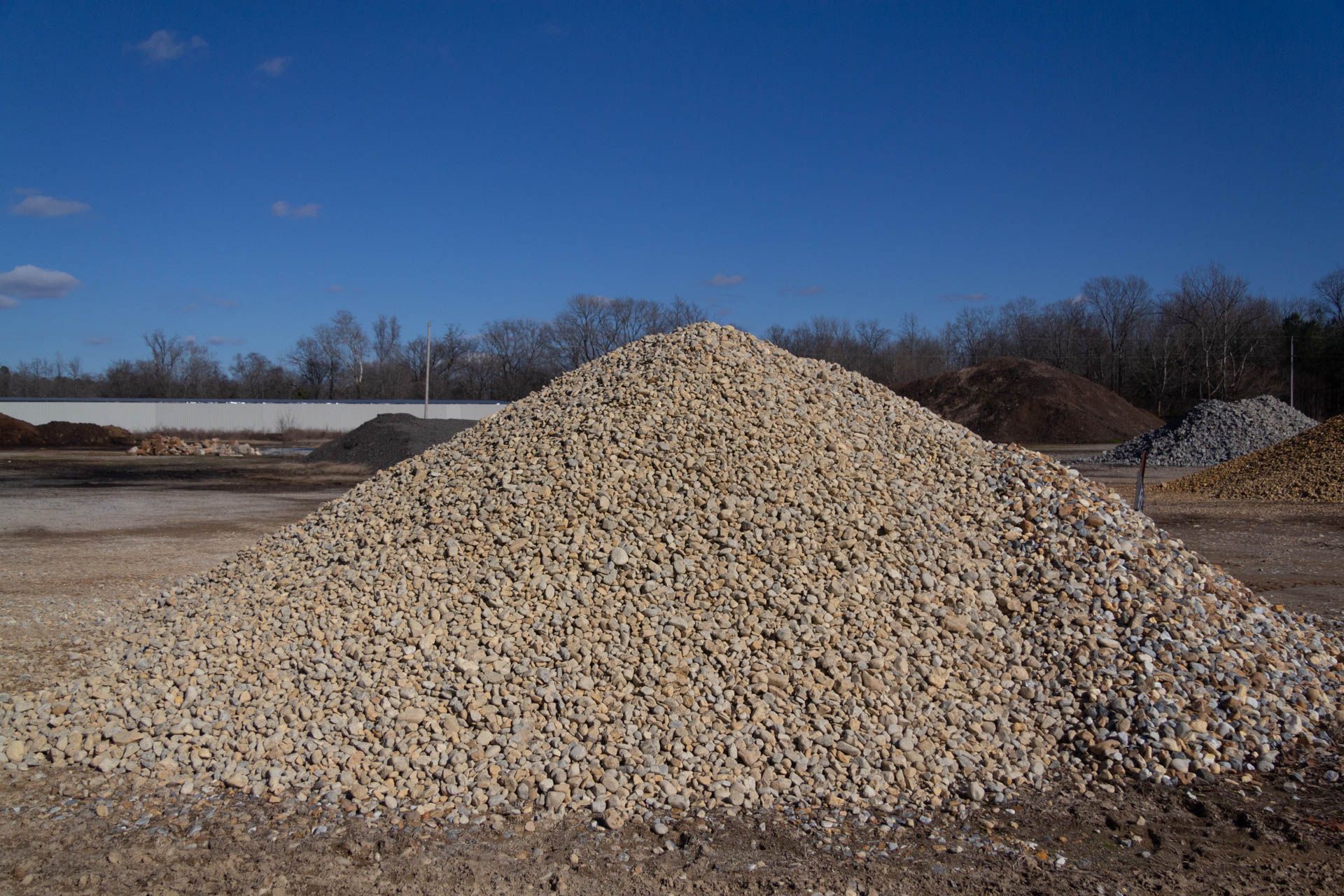 A pile of gravel is sitting on top of a dirt field.