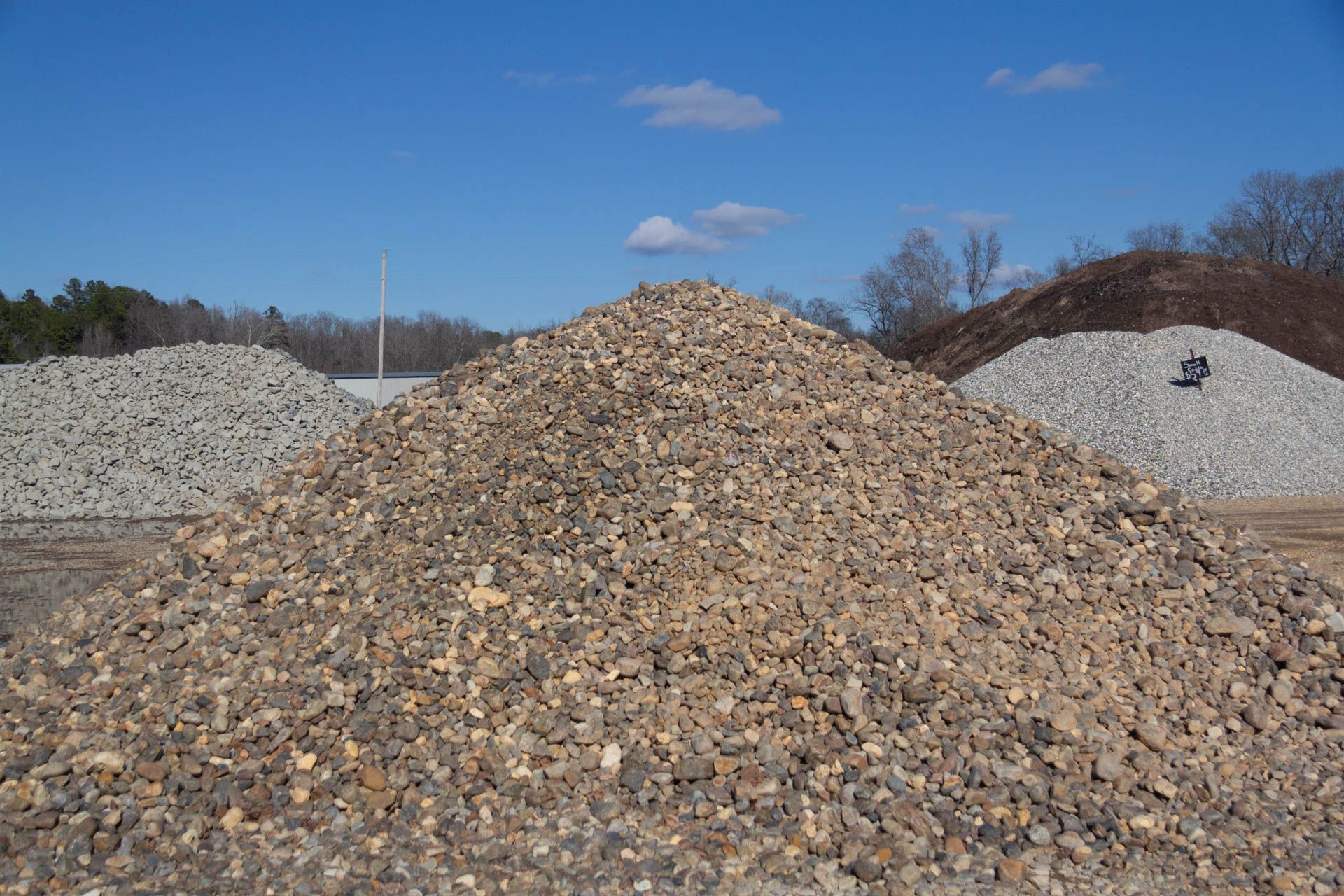 A pile of gravel is sitting in the middle of a field.