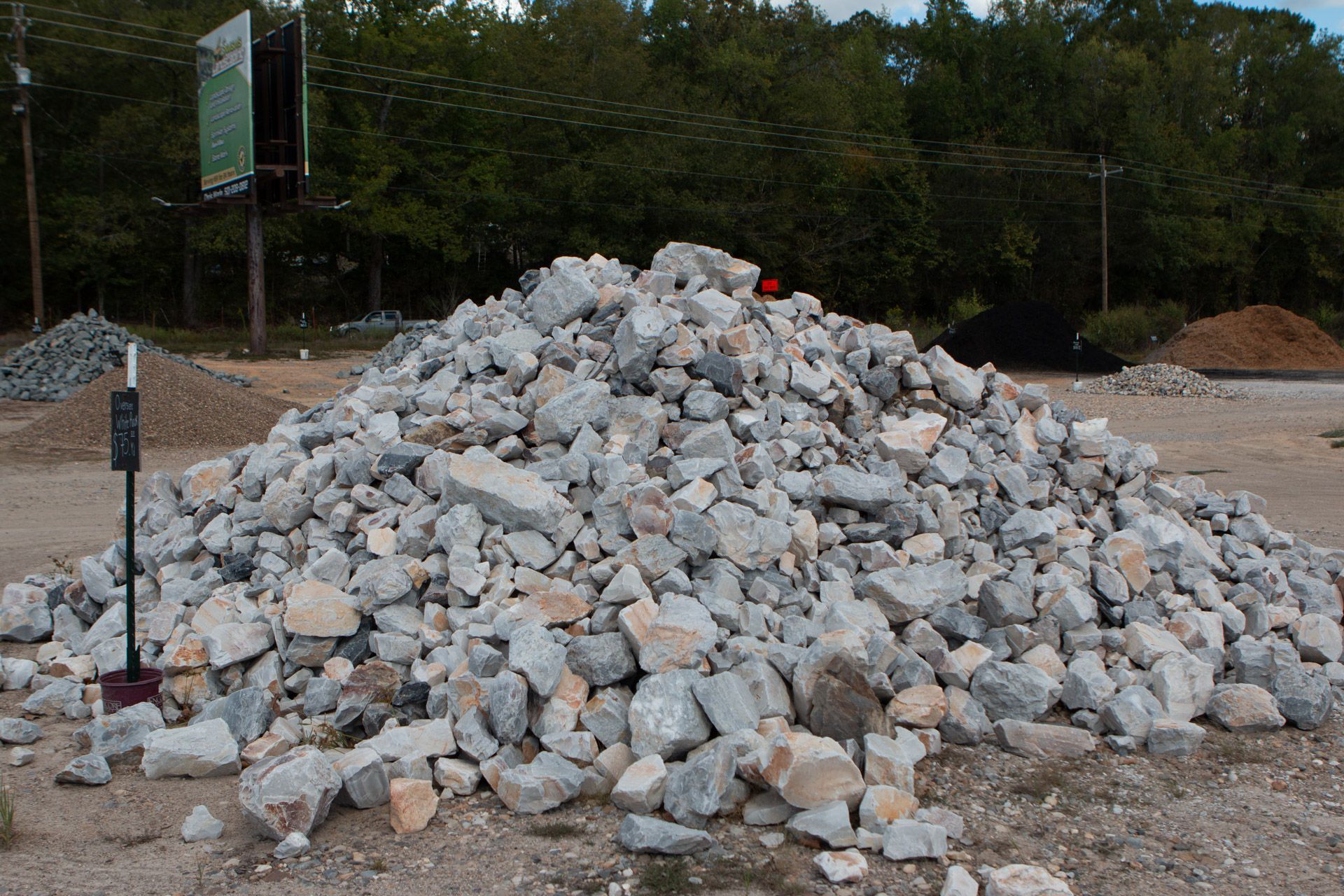 A large pile of rocks is sitting in a dirt field.