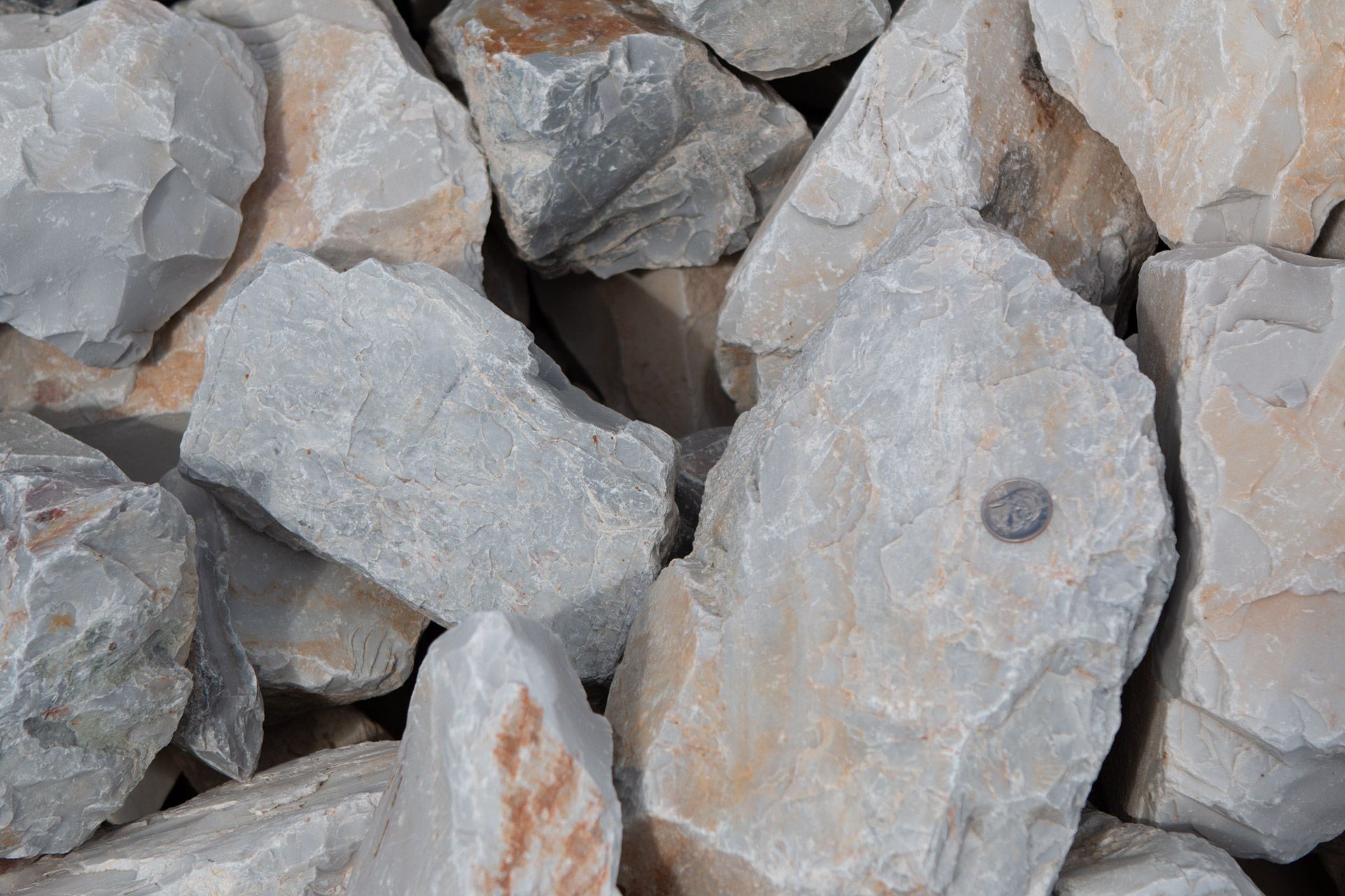 A pile of rocks with a penny sticking out of one of them.
