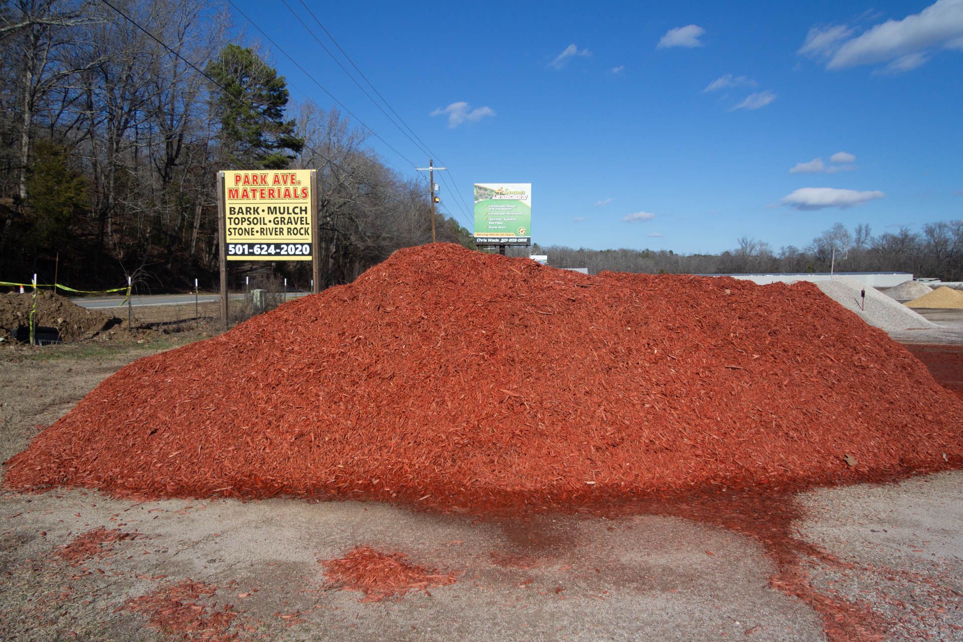 A pile of red mulch is sitting in front of a sign that says fire the materials