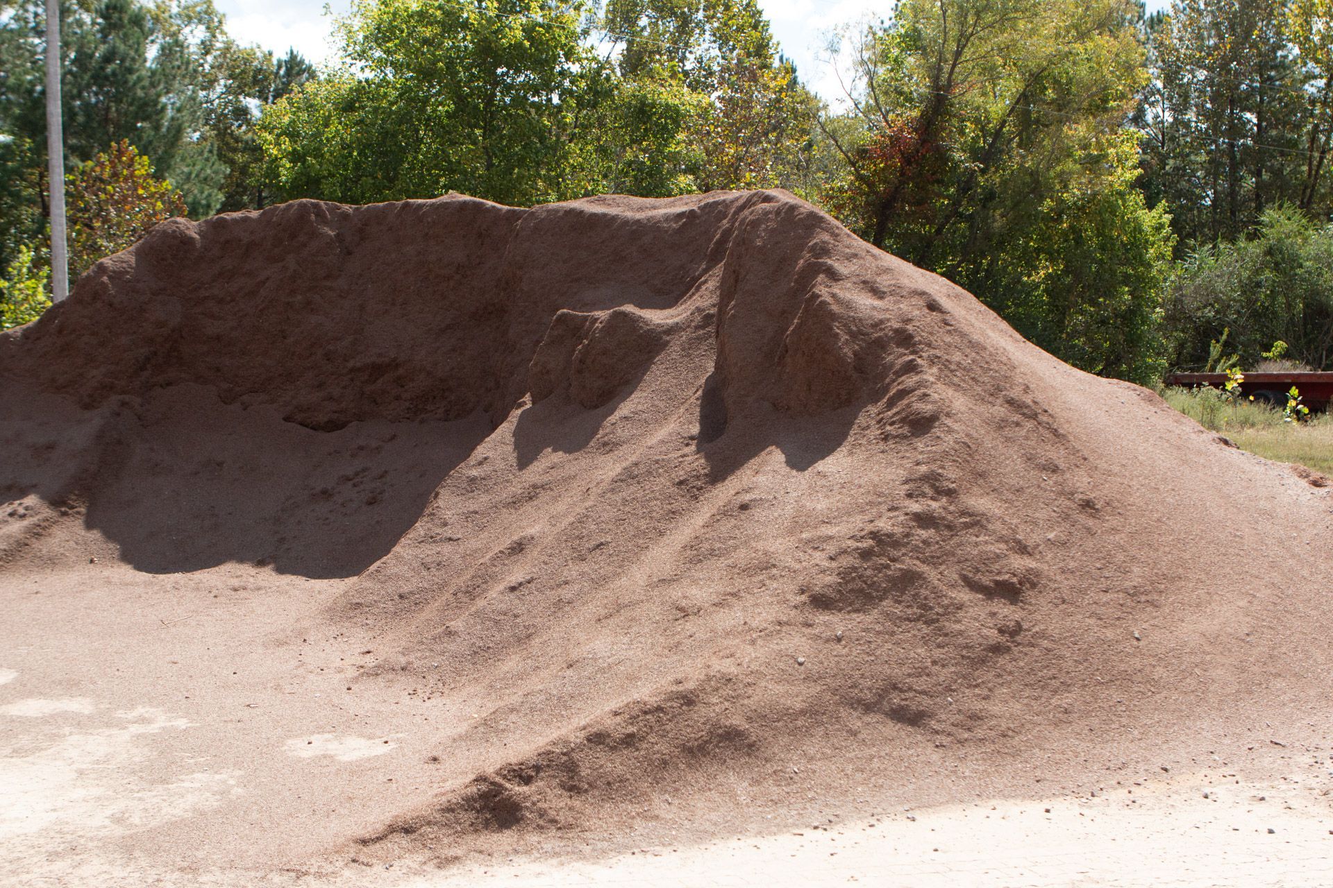 A large pile of dirt is sitting on the side of the road