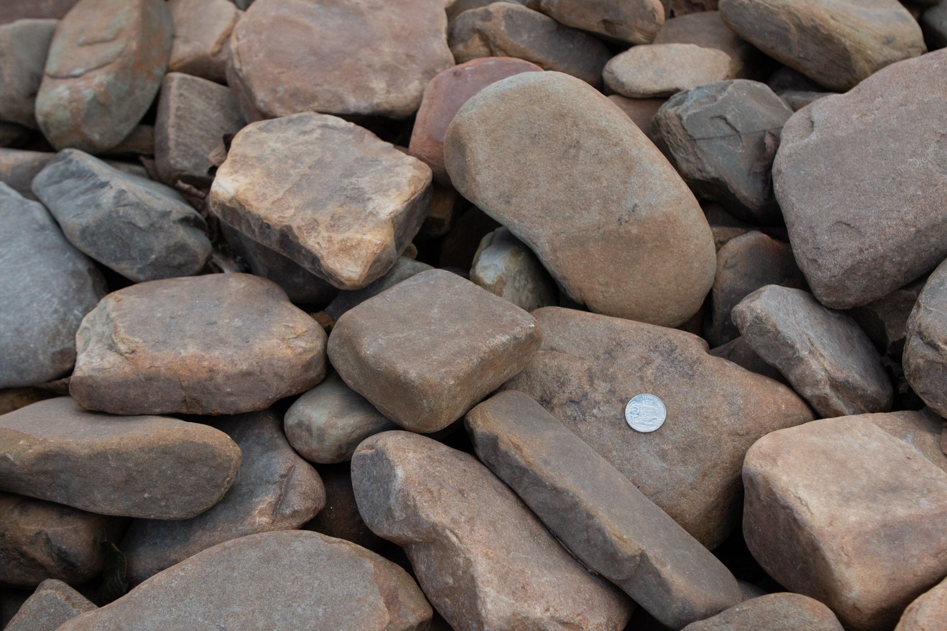 A pile of rocks with a quarter in the middle