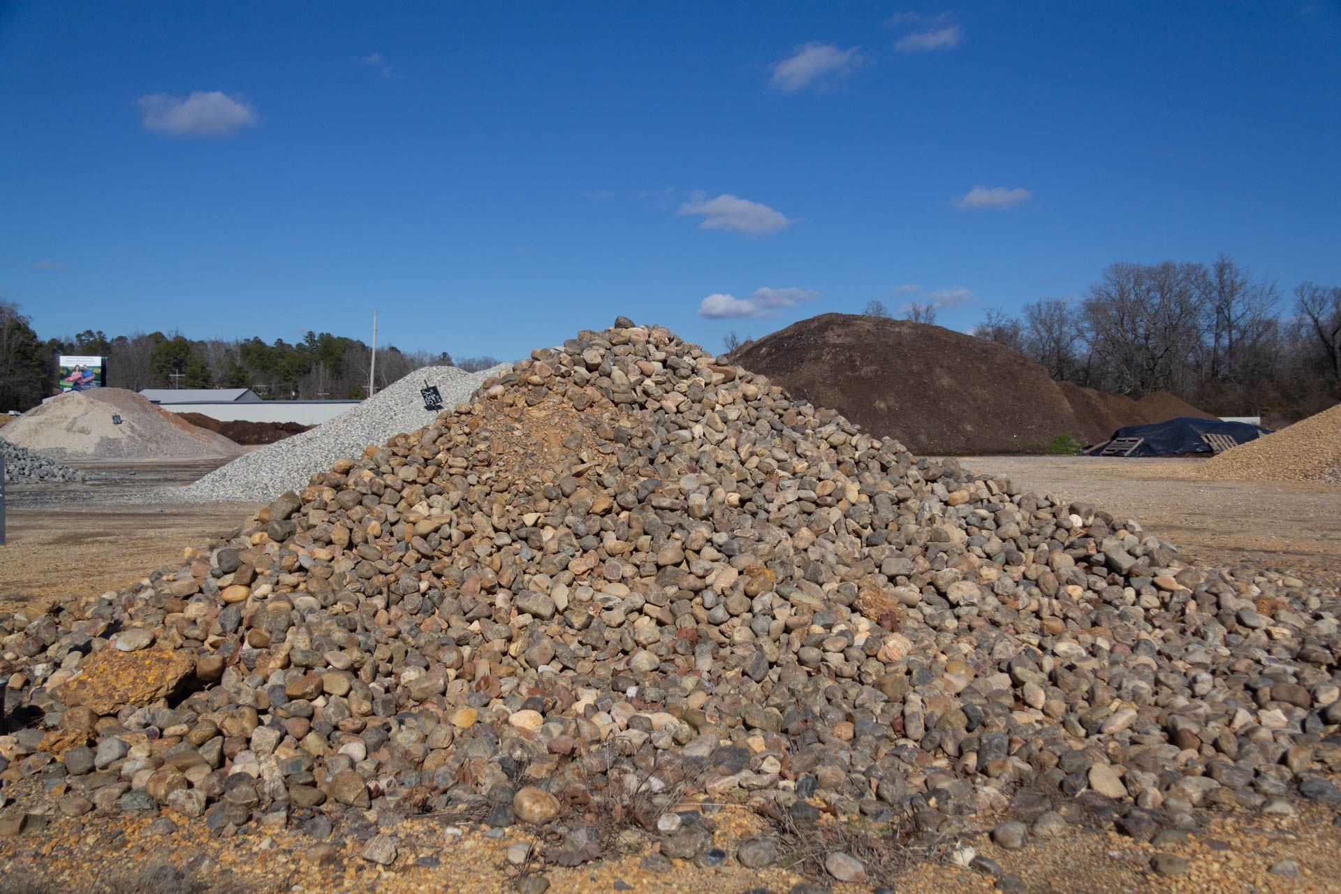 A pile of gravel is sitting on top of a dirt field.
