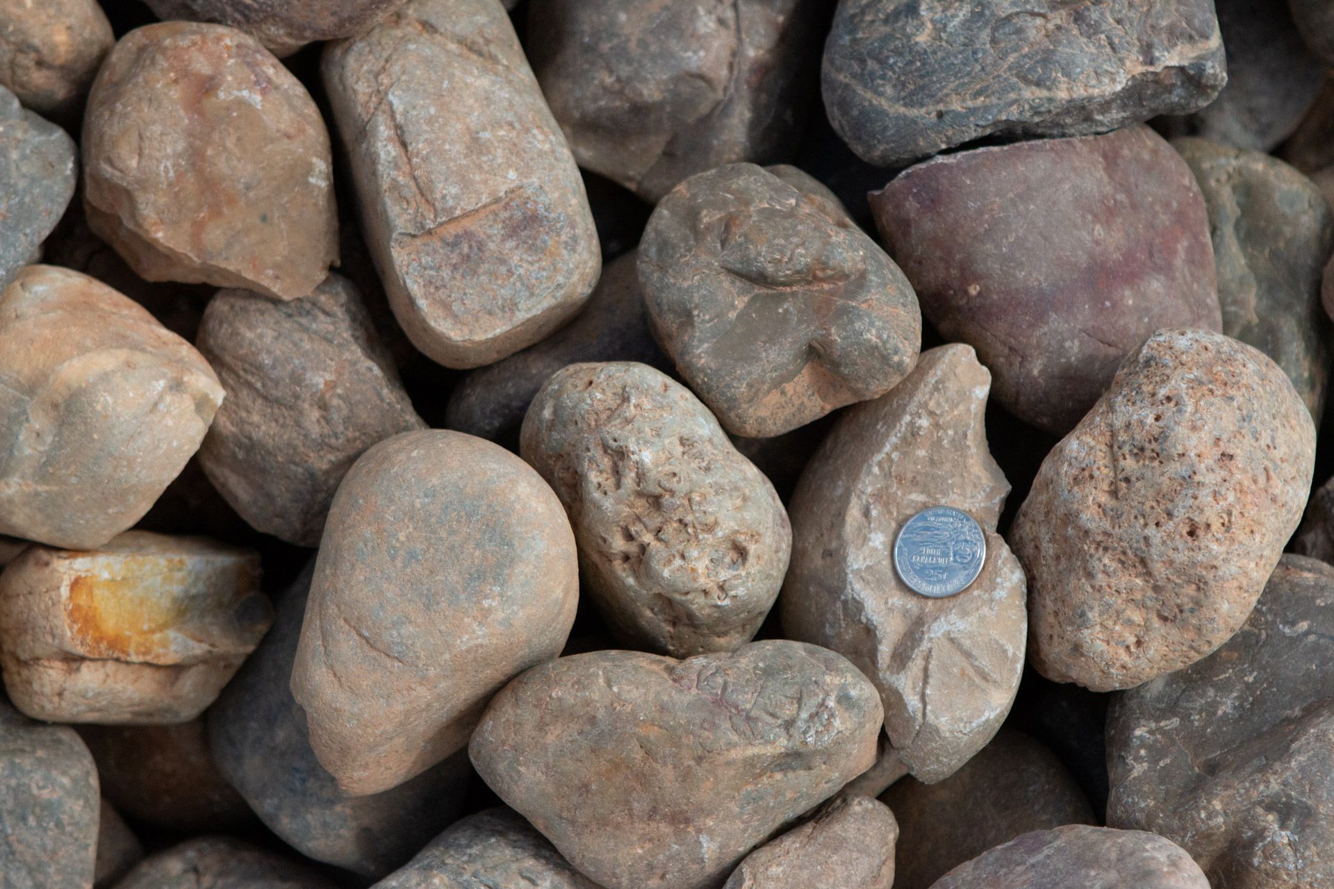 A pile of rocks with a quarter in the middle