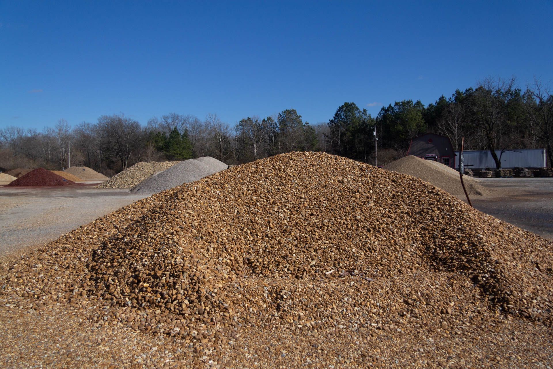 A pile of gravel is sitting on the side of the road