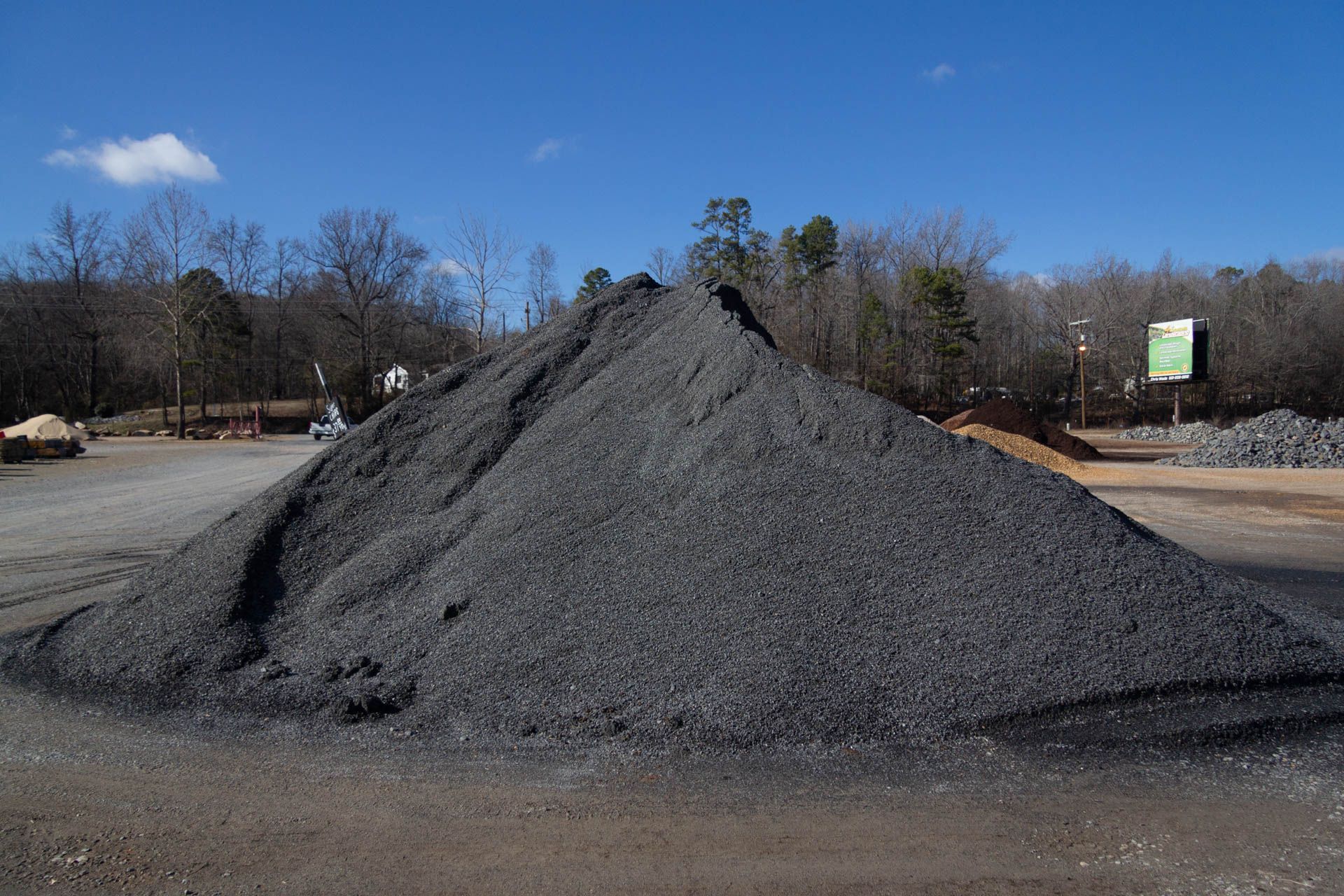 A large pile of gravel is sitting in a parking lot.