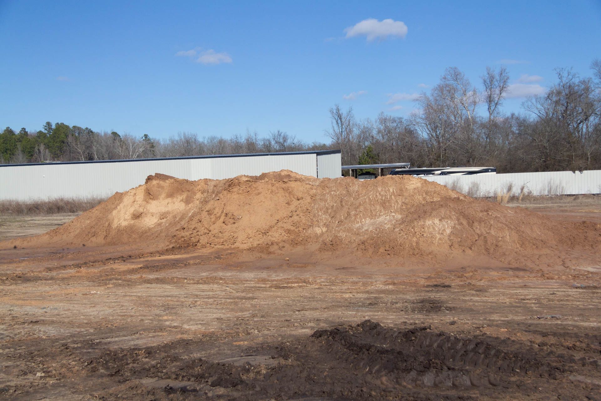 There is a large pile of dirt in the middle of a field.