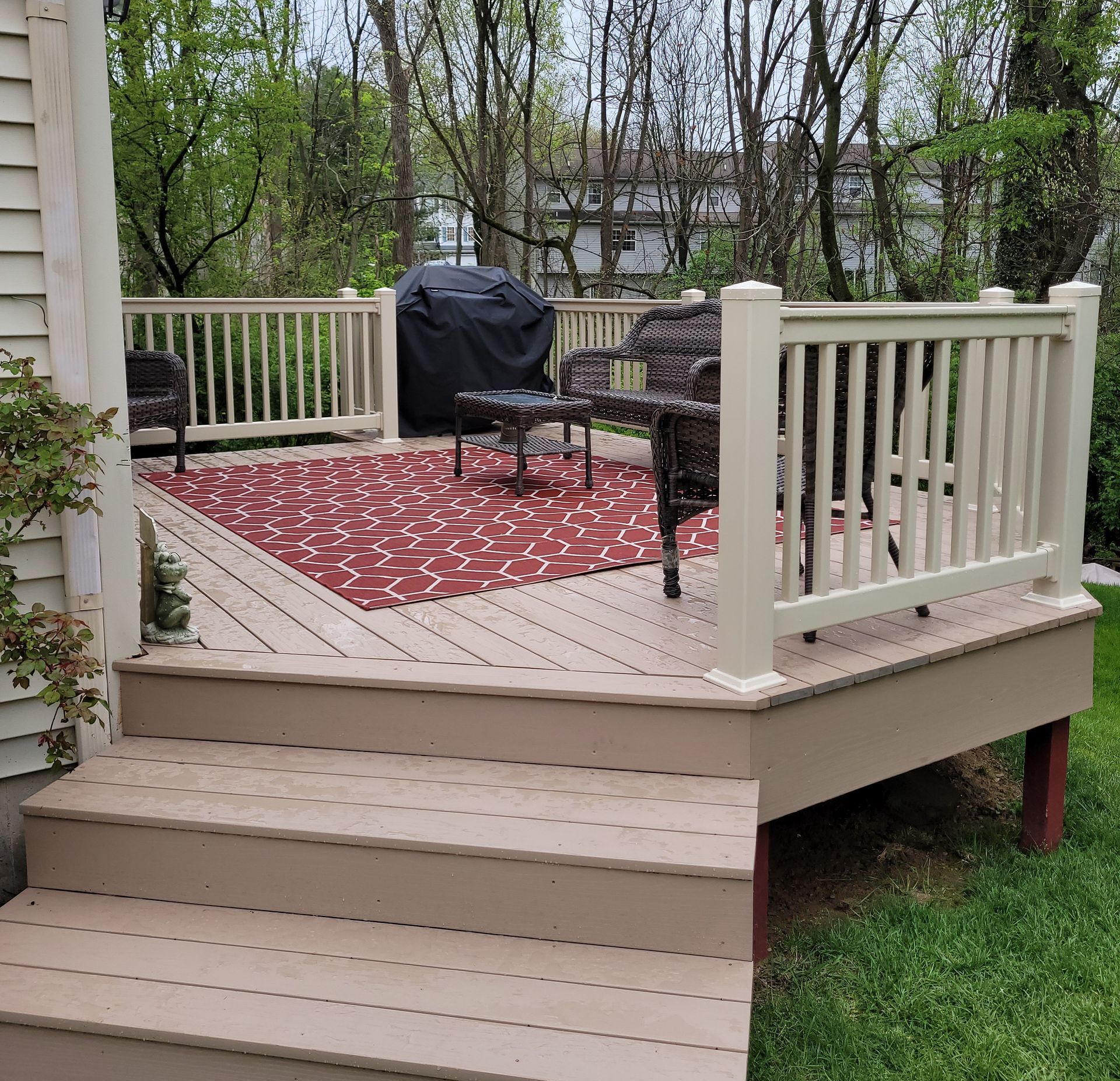 A deck with chairs and a grill on it