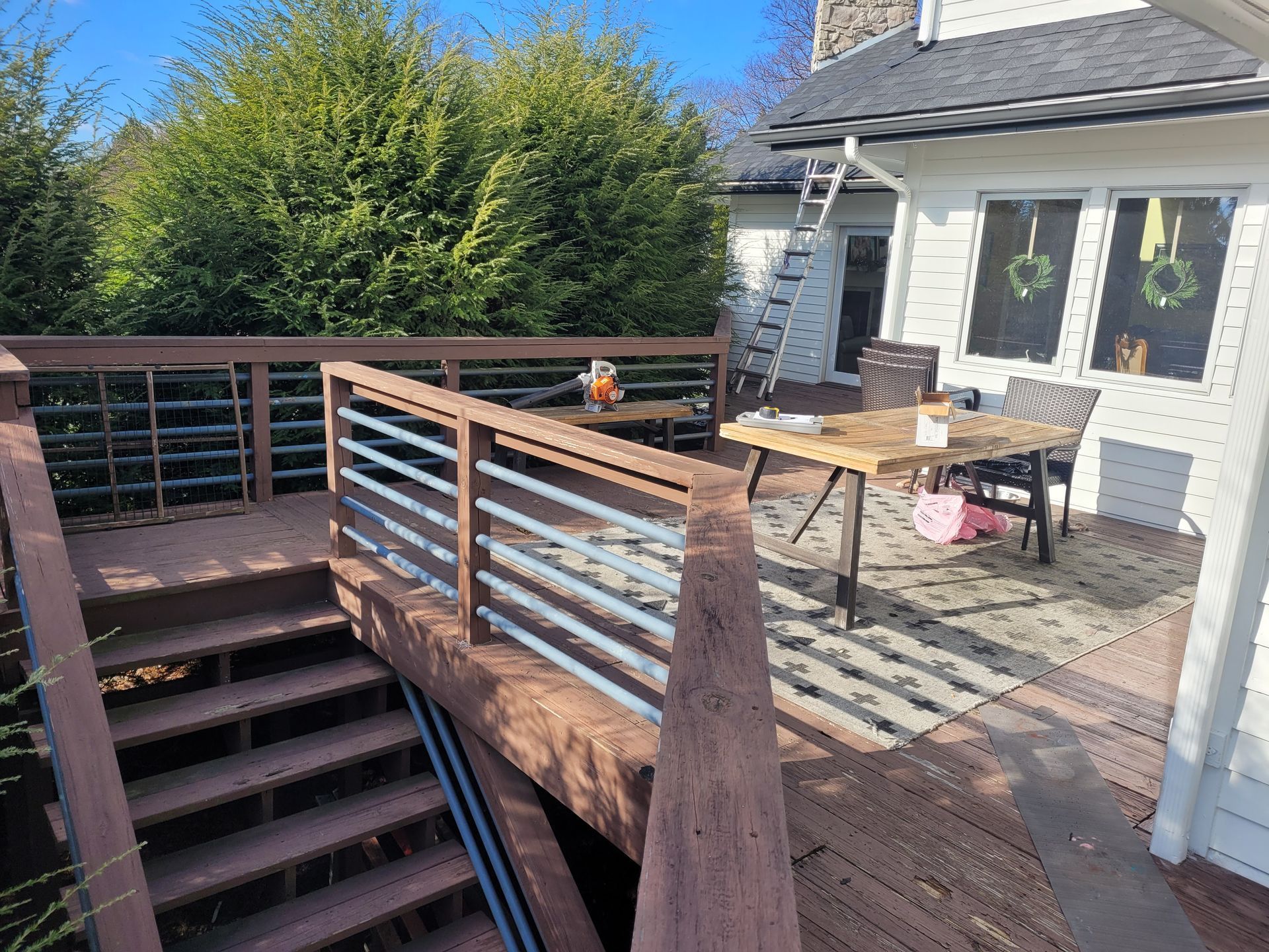 A wooden deck with stairs leading up to it and a table and chairs on it.