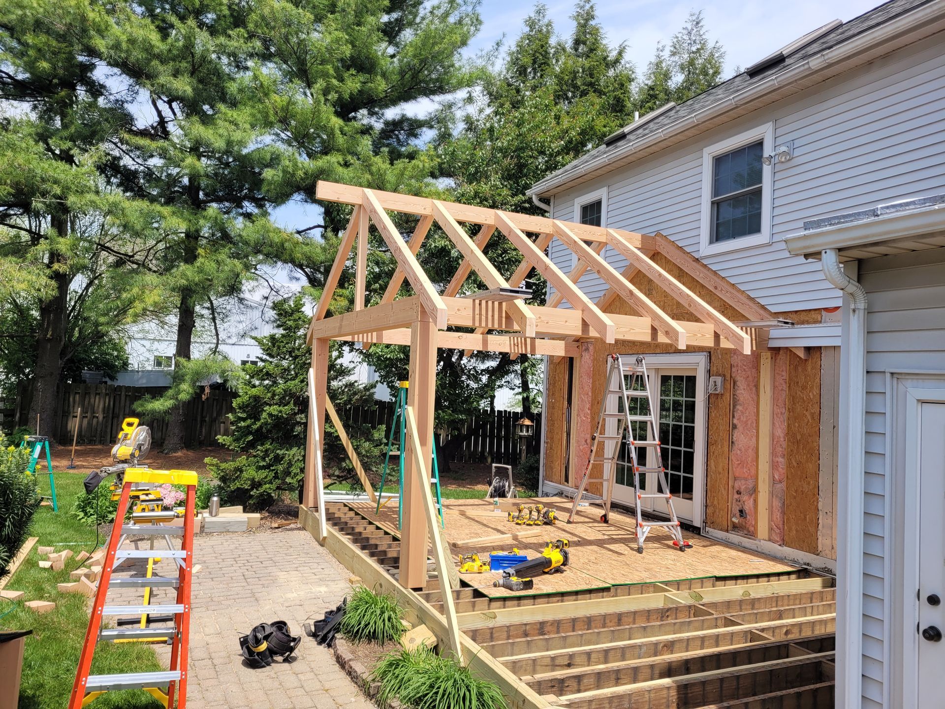 A wooden structure is being built on the side of a house.