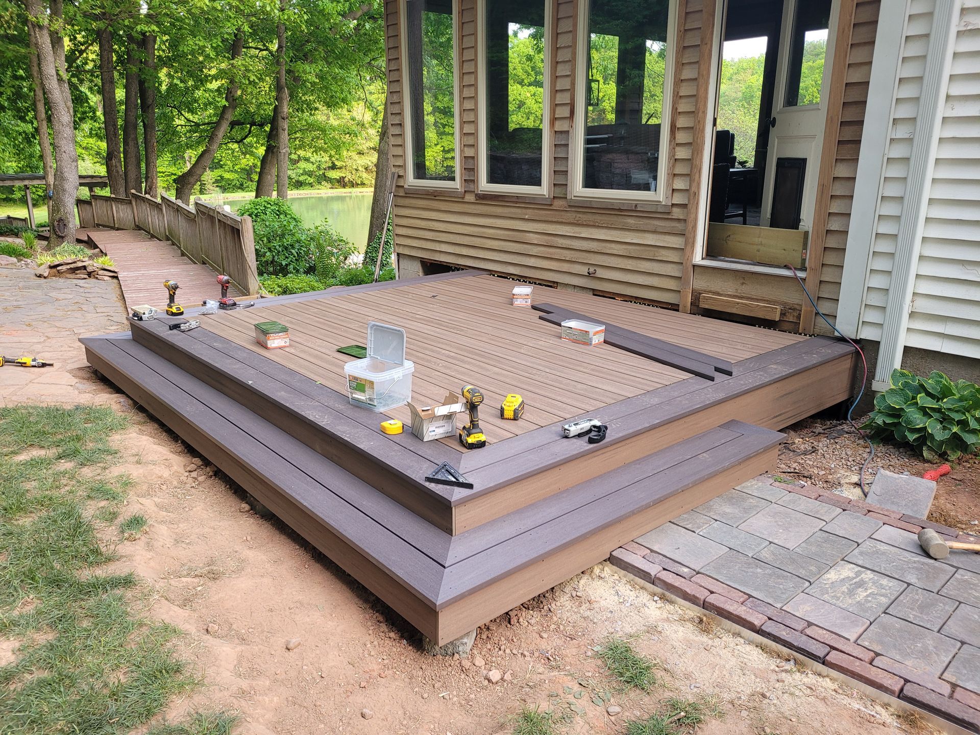 A wooden deck is being built in front of a house.