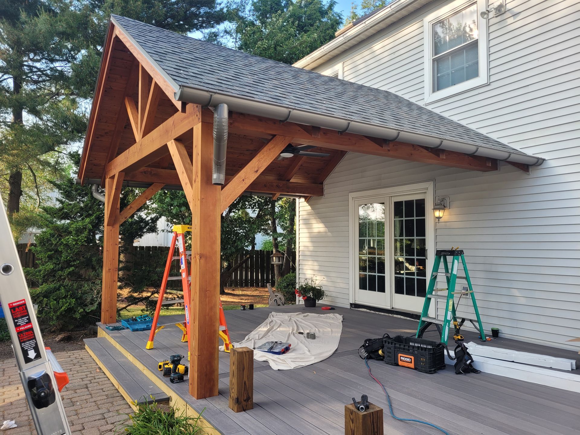 A wooden pavilion is being built in front of a white house.