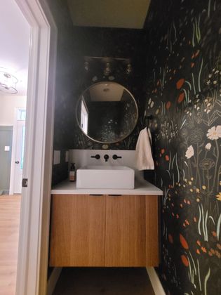 A bathroom with a sink and a round mirror