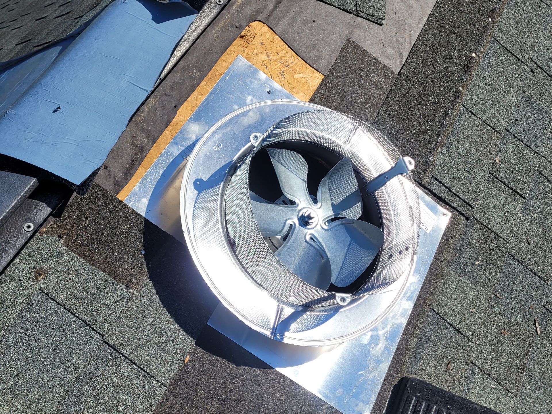 A fan is sitting on top of a roof