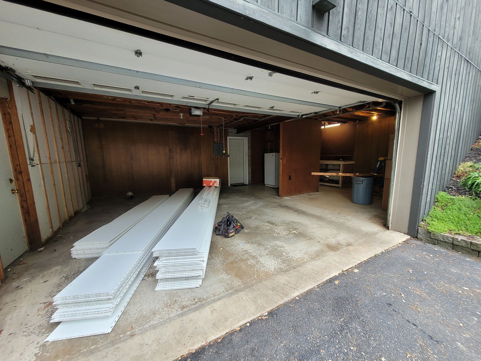 A garage with a lot of white boards in it.