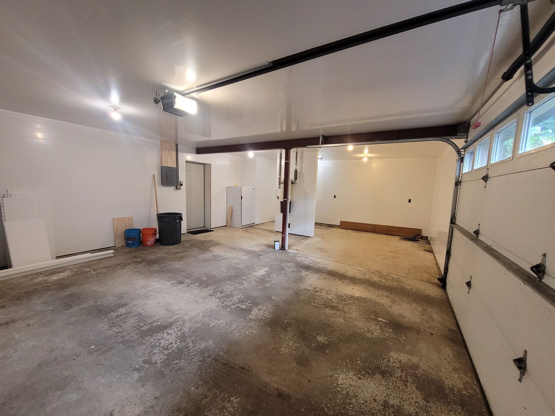 A large empty garage with a garage door open.