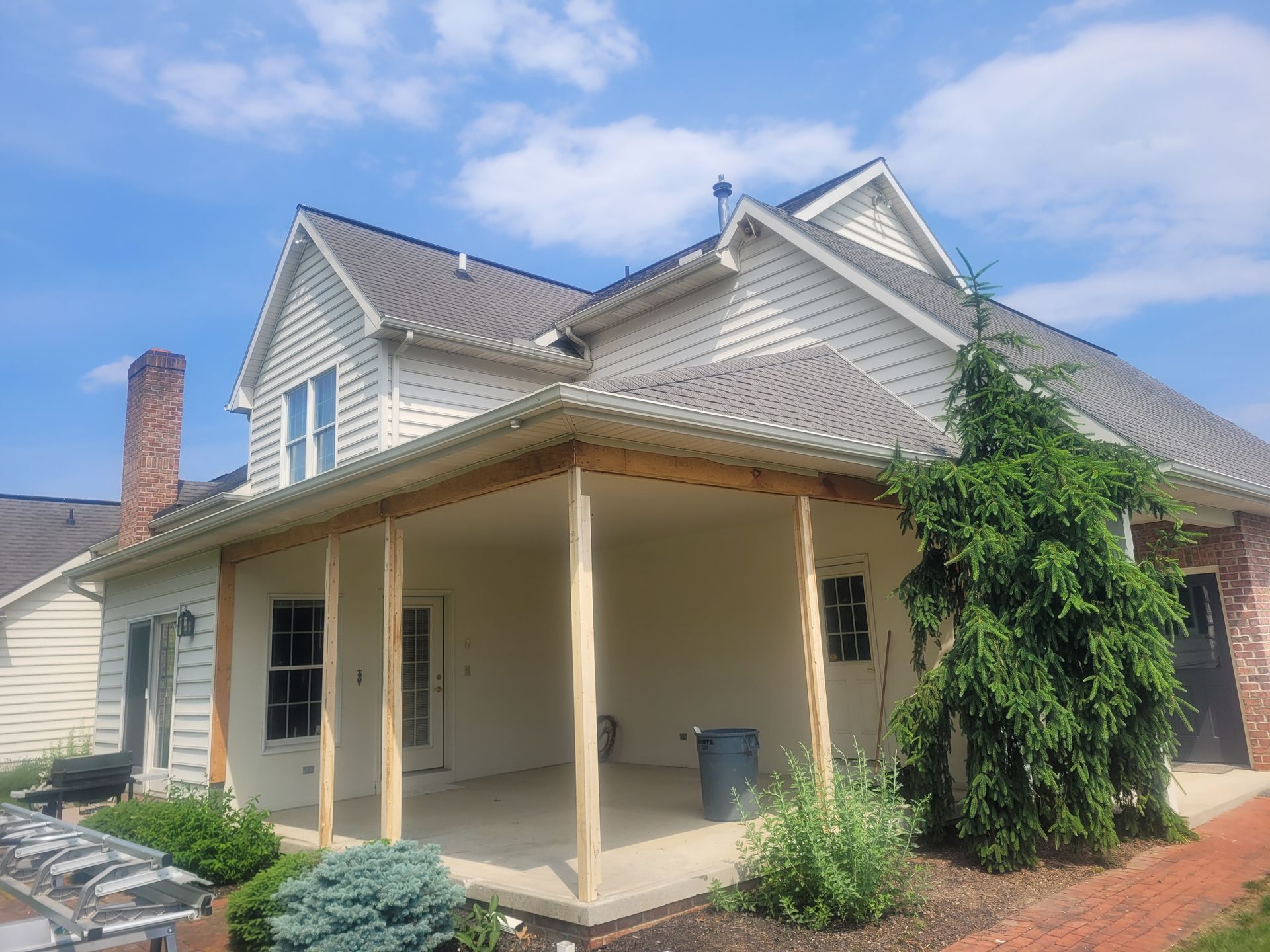 A white house with a porch and a gray roof