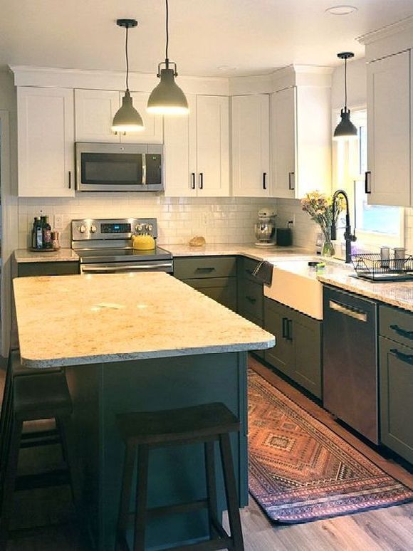 A kitchen with white cabinets , stainless steel appliances , and a large island.