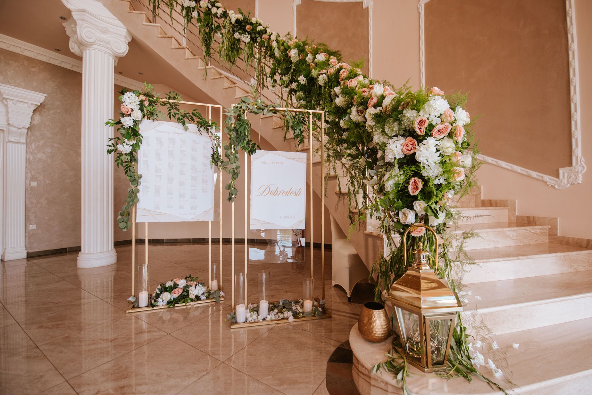 Elegant floral staircase decor with white and blush roses draped along a peach-toned grand staircase.