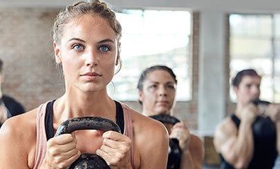workout class holding kettlebell weights