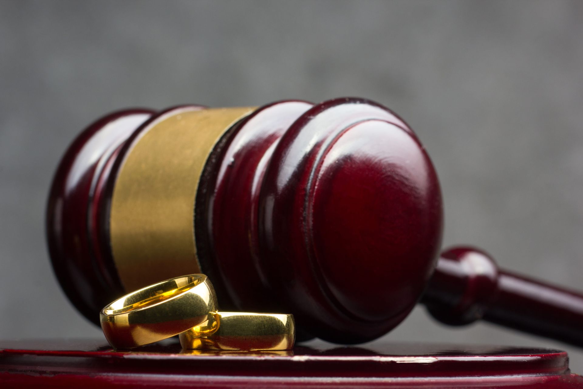 Gavel with brass band and sound block on a dark surface, symbolizing law or justice