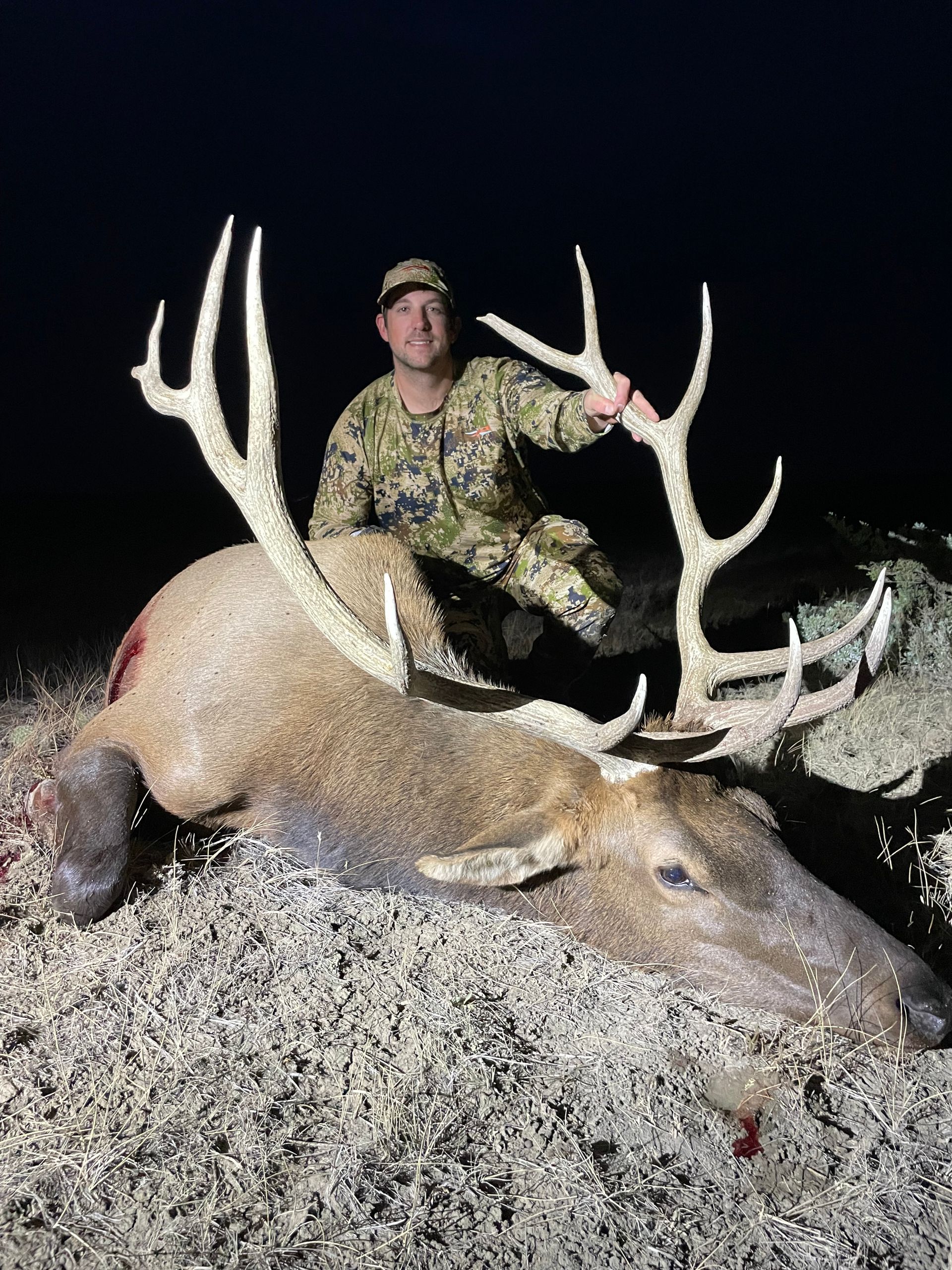 Man posing with deer in a forest