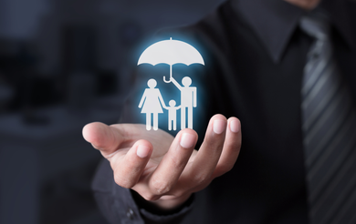 Hand holding glowing family and umbrella icon, suggesting insurance protection