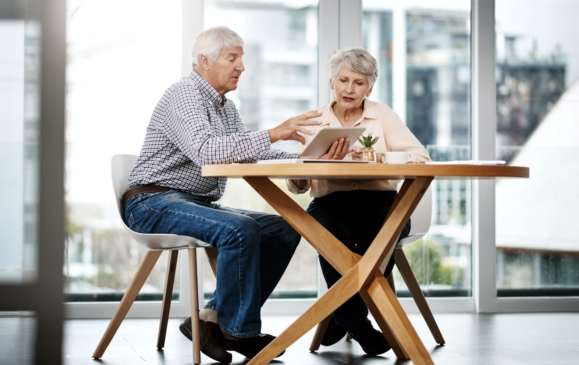 Two people talking at a wooden table in a bright, modern room