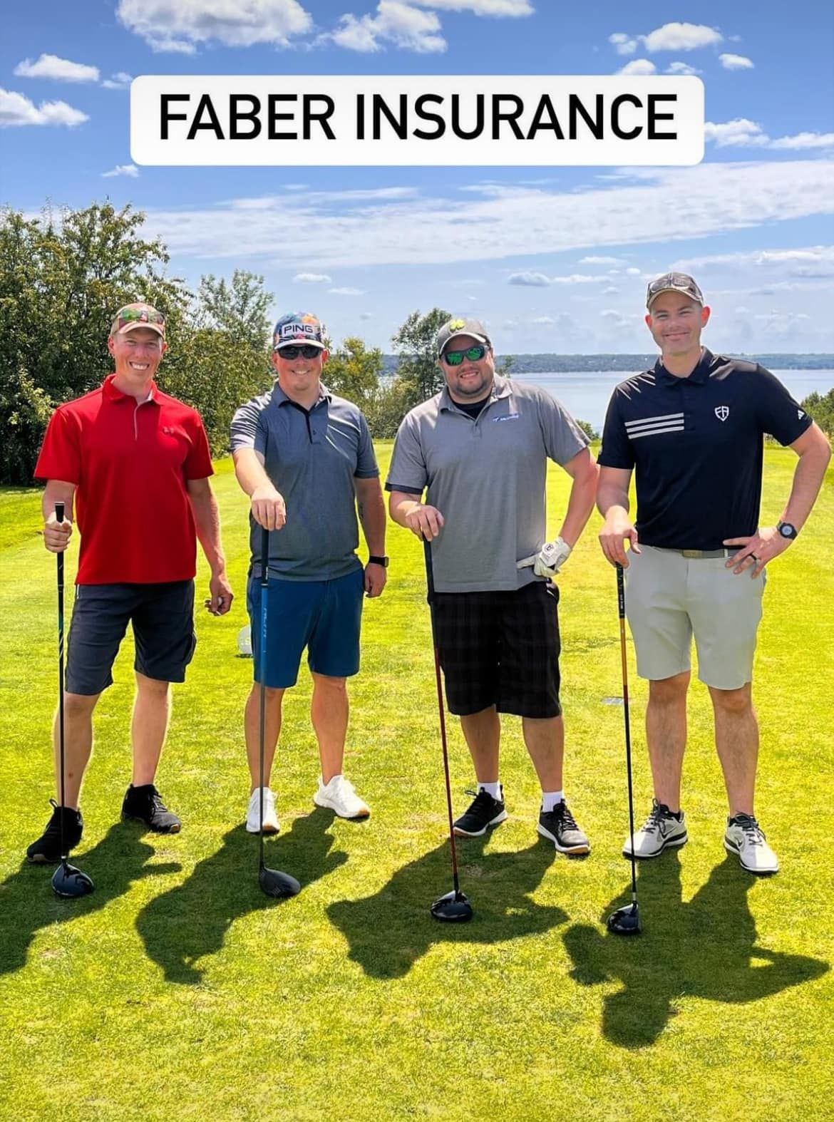 Four people stand on a sunny golf course, each holding a golf club, with 
