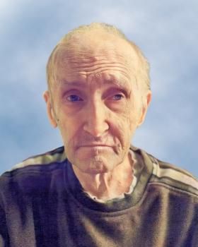 Un gros plan du visage d'un homme avec un ciel bleu en arrière-plan.