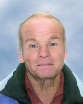 Un gros plan du visage d'un homme avec un ciel bleu en arrière-plan.