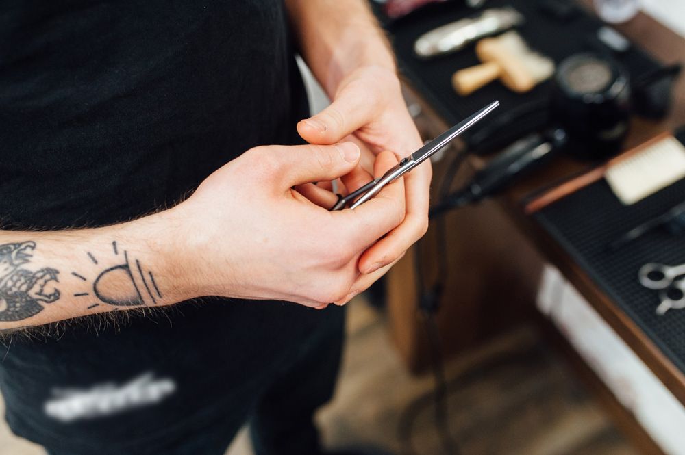 Barber Holding Scissors — Mobile Scissor Sharpening in Gympie, QLD