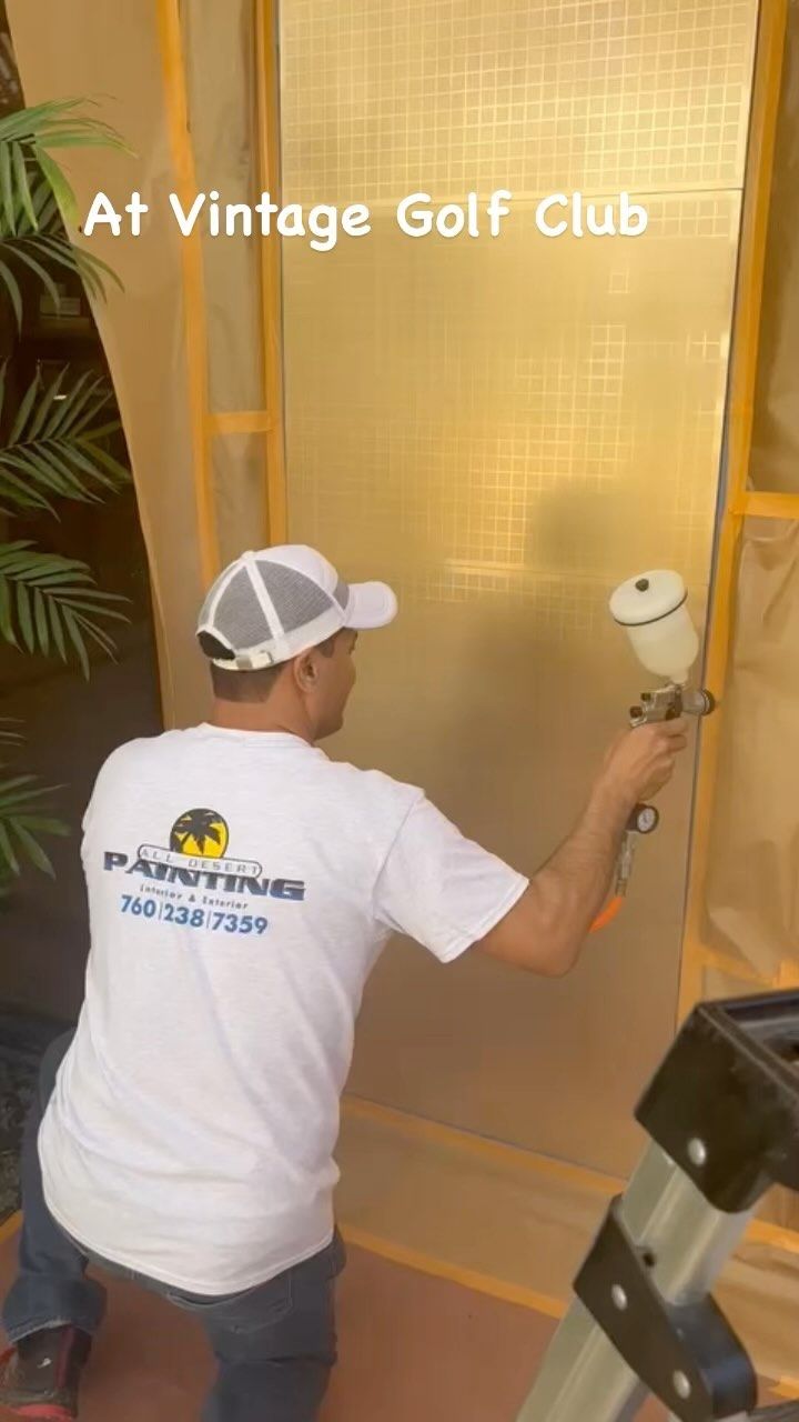 Man spraying a gold wall at Vintage Golf Club with a paint sprayer